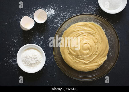 Base torta fatta in casa o pasta biscotto in recipiente di vetro con gli ingredienti sul lato, fotografato overhead su ardesia con luce naturale (messa a fuoco selettiva) Foto Stock