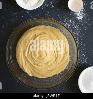 Base torta fatta in casa o pasta biscotto in recipiente di vetro con gli ingredienti sul lato, fotografato overhead su ardesia con luce naturale (messa a fuoco selettiva) Foto Stock