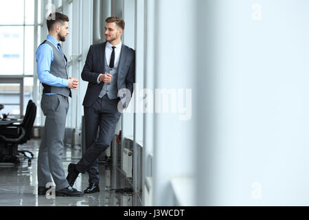 Due colleghi di lavoro alla riunione in ufficio moderno interno. Foto Stock