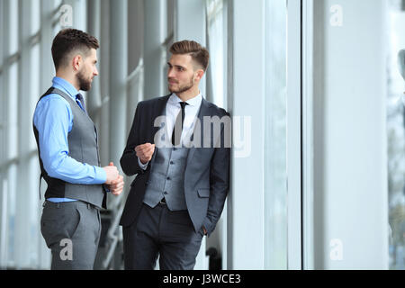 Due colleghi di lavoro alla riunione in ufficio moderno interno. Foto Stock