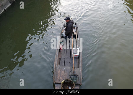 Uomo in un antica barca di legno sui canali di acqua di Xitang cittadina in provincia di Zhejiang, Cina, febbraio 20, 2016. Foto Stock