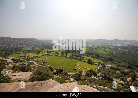 Vista dalle colline Anjaneya in Hampi, Karnataka, India. Villaggio di Hampi visto in background. Foto Stock