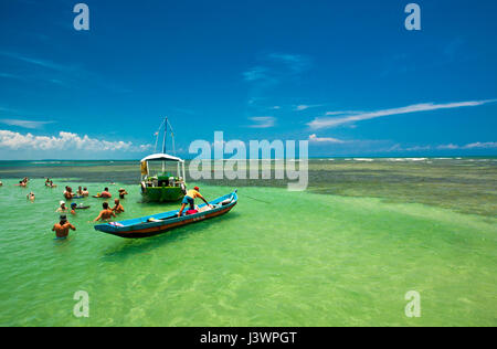 Tourist celebrando con bevande in una piscina naturale a Boipeba, brasile Foto Stock