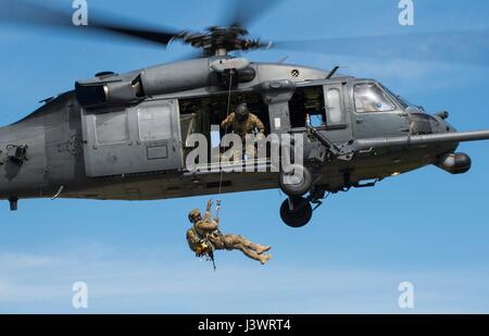 Un U.S. pararescueman soldato è issato su un USAF HH-60G Pave Hawk elicottero durante un combattimento di ricerca e salvataggio di dimostrazione presso la Royal Air Force Lakenheath Aprile 21, 2016 in Lakenheath, Inghilterra. (Foto di Emerson Nunez /US Air Force via Planetpix) Foto Stock