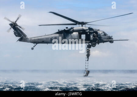 Forze speciali DEGLI STATI UNITI, soldati salire su un USAF HH-60G Pave Hawk elicottero durante la corda-scala di formazione di recupero 22 Settembre 2015 vicino a Okinawa, Giappone. (Foto di Giovanni Linzmeier /US Air Force via Planetpix) Foto Stock