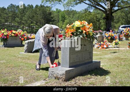 Vernon, AL., Stati Uniti d'America. Il 7 maggio, 2017. Onorevole Ward luoghi fiori a suo nonno grave al forno Hill Cimitero in Vernon, Alabama. Domenica 7 Maggio è stato il giorno di decorazione. Credito: Tim Thompson/Alamy Live News Foto Stock