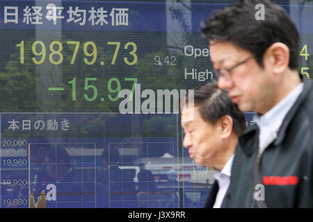 Tokyo, Giappone. 9 maggio 2017. I pedoni a piedi passato un magazzino elettronico di bordo che mostra in Giappone il Nikkei media Stock nei primi mesi di negoziazione il 9 maggio 2017, Tokyo, Giappone. La borsa giapponese media è scesa 18.62 punti o 0,09% a 19,872.25 sui suoi primi quindici minuti all'inizio Martedì trading, dopo la sua chiusura alta sulla Francia elezioni presidenziali risultato il lunedì. Credito: Rodrigo Reyes Marin/AFLO/Alamy Live News Foto Stock