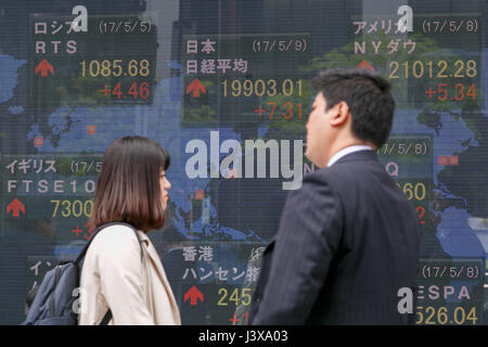 Tokyo, Giappone. 9 maggio 2017. I pedoni a piedi passato un magazzino elettronico di bordo che mostra in Giappone il Nikkei media Stock nei primi mesi di negoziazione il 9 maggio 2017, Tokyo, Giappone. La borsa giapponese media è scesa 18.62 punti o 0,09% a 19,872.25 sui suoi primi quindici minuti all'inizio Martedì trading, dopo la sua chiusura alta sulla Francia elezioni presidenziali risultato il lunedì. Credito: Rodrigo Reyes Marin/AFLO/Alamy Live News Foto Stock