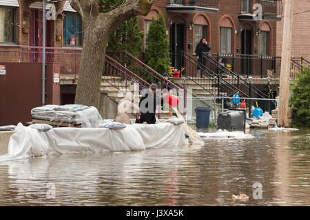 Montreal, Canada. 8 Maggio, 2017. Residenti bail inondazione come le inondazioni hits Cousineau street Credit: Marc Bruxelle/Alamy Live News Foto Stock