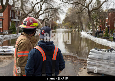 Montreal, Canada. 8 Maggio, 2017. I vigili del fuoco a valutare la situazione come le inondazioni hits Cousineau street Credit: Marc Bruxelle/Alamy Live News Foto Stock