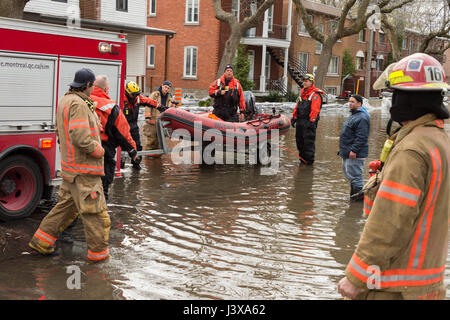 Montreal, Canada. 8 Maggio, 2017. I vigili del fuoco utilizza un gommone per aiutare gli abitanti come le inondazioni hits Cousineau street Credit: Marc Bruxelle/Alamy Live News Foto Stock