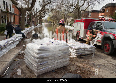 Montreal, Canada. 8 Maggio, 2017. I vigili del fuoco disimballare sacchi di sabbia come le inondazioni hits Cousineau street Credit: Marc Bruxelle/Alamy Live News Foto Stock