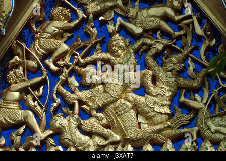 Oro raffigurazione di stampaggio di guerrieri in battaglia su uno sfondo di blose piastrelle in vetro, il Grand Palace, Bangkok Foto Stock