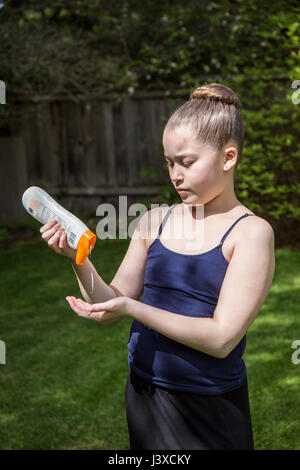 Di undici anni ragazza l'applicazione di crema solare in Issaquah, Washington, Stati Uniti d'America Foto Stock