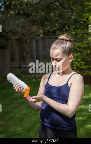 Di undici anni ragazza l'applicazione di crema solare in Issaquah, Washington, Stati Uniti d'America Foto Stock