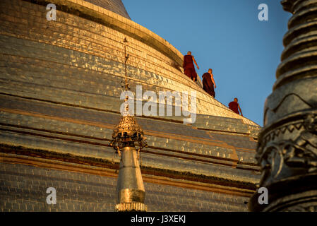 Myanmar tre monaci a piedi intorno alla Pagoda Shwesandaw mentre il vostro tempo di preghiera. Foto Stock