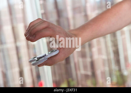 Giovane ragazzo giocando con agitano: spinner giocattolo per alleviare lo stress a casa Foto Stock