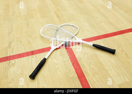 Racchette da squash e la sfera sulla corte vicino alla linea rossa. Raquetball attrezzatura. Foto con il fuoco selettivo Foto Stock