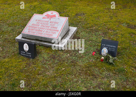 Tomba di massa di 1.407 Armata Rossa soldati caduti durante la Seconda Guerra Mondiale sul terreno della guerra sovietica Memorial presso il cimitero centrale di Brno, in Repubblica Ceca. Fotografie di militare sovietico officer Boris Mishenkov (L) e civili di Vera Stepanova (R) sono stati installati dai parenti dopo la guerra. Esercito Rosso tenente Boris Mishenkov è nato il 24 luglio 1909 e morì di ferite all'età 35 su 13 Maggio, 1945. Vera Stepanova è nato il 30 luglio 1925, servita nell'Armata Rossa come dattilografa e morì di tifo all'età di 19 il 6 giugno 1945. La sua fotografia è stata invano restaurato di recente da ignoti dilettanti. Foto Stock