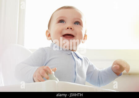 Blue eyed baby boy sulla sedia alta Foto Stock