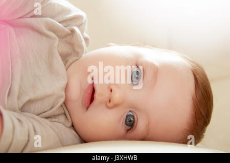 Close up ritratto di blue eyed baby boy sdraiato sul divano Foto Stock