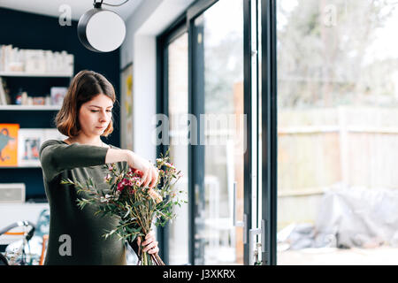 Fioraio studente disponendo bouquet di fiori a organizzare workshop Foto Stock