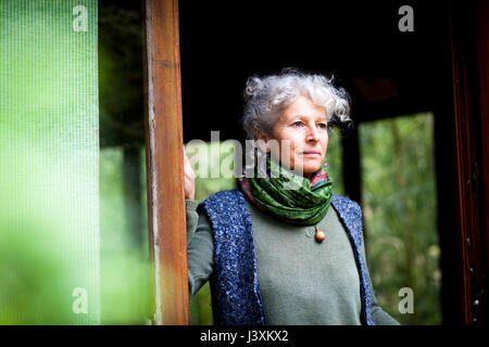 Ritratto di donna dentro la porta che guarda lontano Foto Stock