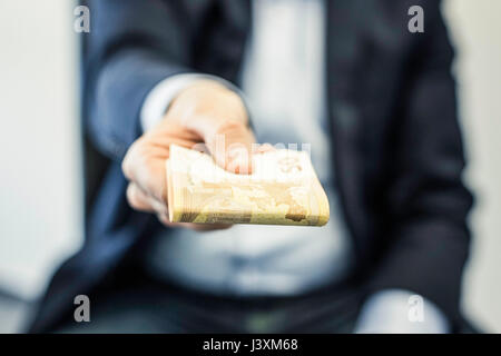 Imprenditore il lato trasmissione piegato cinquanta le banconote in euro Foto Stock