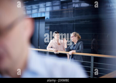 Due imprenditrici avente la discussione sul balcone di office Foto Stock