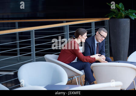 Imprenditrice e uomo avente incontro sul balcone di office Foto Stock