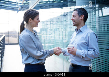 Imprenditore e la donna si stringono la mano sul balcone di office Foto Stock