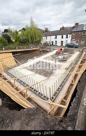 Basamenti in cemento preparato per la nuova build house infill plot scavate nel banco di Abergavenny, Wales, Regno Unito Foto Stock