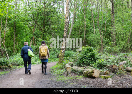 Due persone su pista forestale attraverso zone umide di Newport, Wales, Regno Unito Foto Stock