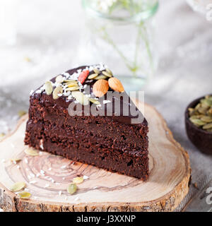 Vegano barbabietole al cioccolato torta con glassa di avocado, decorate con noci e semi. Foto Stock