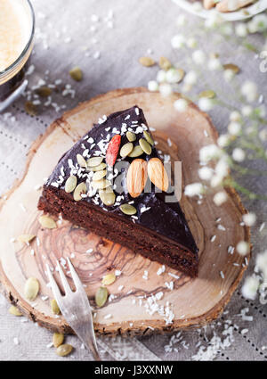 Vegano barbabietole al cioccolato torta con glassa di avocado, decorate con noci e semi. Vista dall'alto. Copia dello spazio. Foto Stock