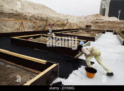 Applicazione del bitume a freddo usando il rullo di vernice Foto Stock