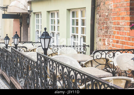 La Street View di un ristorante esterno o aria aperta cafe con la tabella vuota e sedie Foto Stock