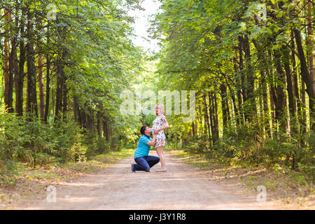 Giovane uomo baciare sua moglie incinta il ventre Foto Stock