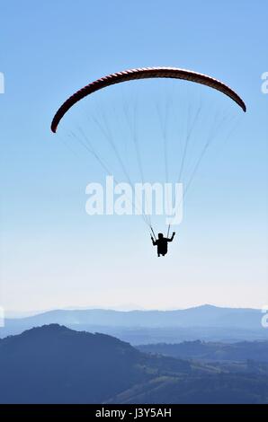 Parapendio nel cielo blu in montagne di Cambuquira, Brasile Foto Stock