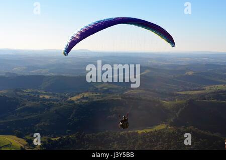 Parapendio nel cielo blu in montagne di Cambuquira, Brasile Foto Stock