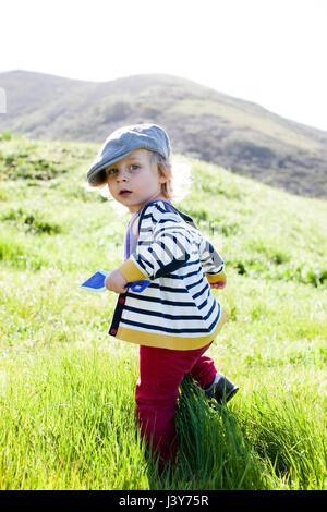 Ritratto di bimbi maschio guardando indietro mentre toddling in erba Foto Stock