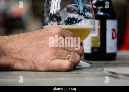 Bottiglia fresca birra. Uomo sposato tenendo un fresco bicchiere di birra in mano. Foto Stock