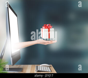 Mano con presente o confezione regalo proviene outo del monitor del PC Foto Stock