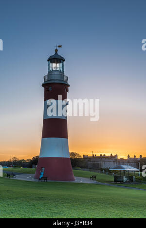 Il sole sorge alle spalle l'iconica Smeatons Tower su Plymouth Hoe in South Devon. Foto Stock