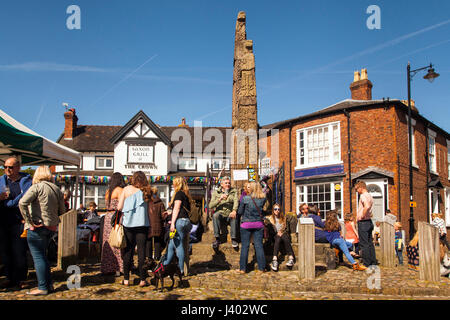 Le persone che si godono il sole intorno alle antiche croci sassoni nella piazza del mercato di Sandbach Cheshire durante il festival dei trasporti Foto Stock