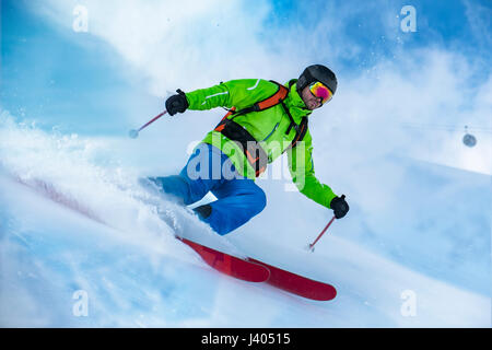 Sorprendente colpo di un colorato vestito con rifiniture a sciare sulla neve onda. Foto Stock