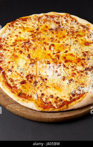 Hot pizza Quattro Formaggi a una tavola in legno rustico. Il cibo italiano. Foto Stock