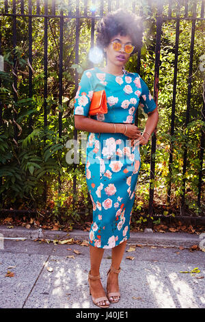 Ritratto di giovane donna fashion blogger con capelli afro in attesa sul marciapiede Park, New York, Stati Uniti d'America Foto Stock
