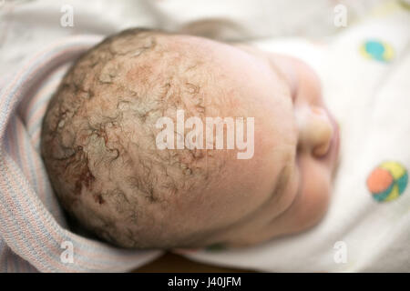 Close up del neonato ragazza avvolto in una coperta addormentato Foto Stock