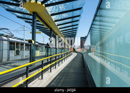 Tram Metrolink e parete di vetro al Deansgate-Castlefield fermata del tram, Manchester, Inghilterra, Regno Unito Foto Stock